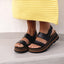 Vista Luxe Liah black sandals facing forward, showing cushioned platform soles and ankle straps for comfort and support.