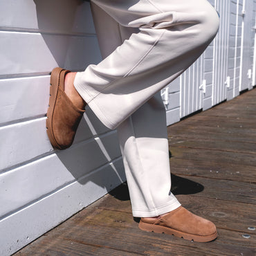 Vista Luxe Mariana shown facing right, brown suede clog worn with beige pants on wooden deck, emphasizing comfort and style.
