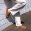 Vista Luxe Mariana shown facing right, brown suede clog worn with beige pants on wooden deck, emphasizing comfort and style.