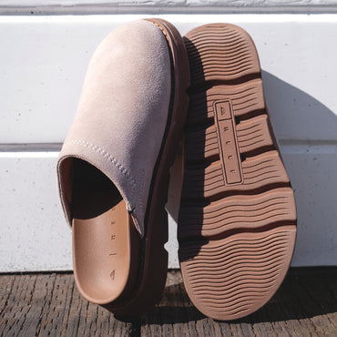 Vista Luxe Mariana clogs in beige suede, left shoe facing right showing closed toe, right shoe sole up with REEF logo visible