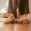 Side view of women's Vista Luxe Solene platform clogs in beige suede, featuring adjustable buckle straps and chunky soles.