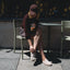 Woman seated outdoors wearing Vista Myra facing left, women's warm sand leather clog with enhanced arch support and soft cushioning