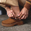 Close-up of left foot showing the adjustable backstrap and buckle on the right-facing Vista Skye Rosa clog in brown leather