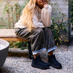 Weekend Autumn black ankle boots facing forward on a woman outdoors with cozy autumn styling