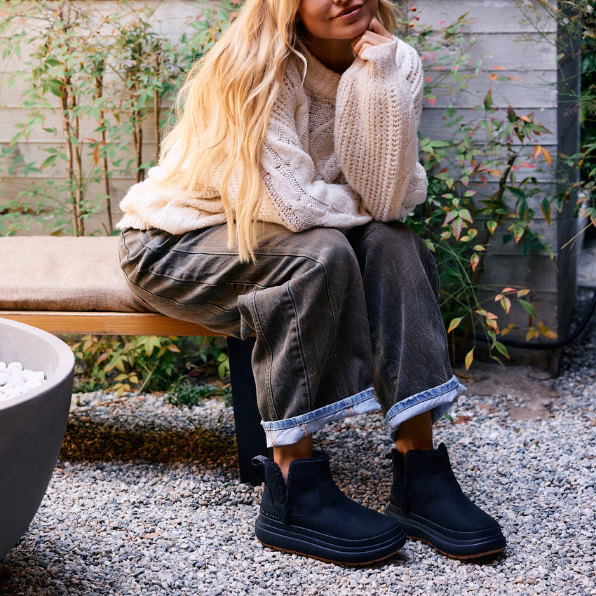 Weekend Autumn black ankle boots facing forward on a woman outdoors with cozy autumn styling