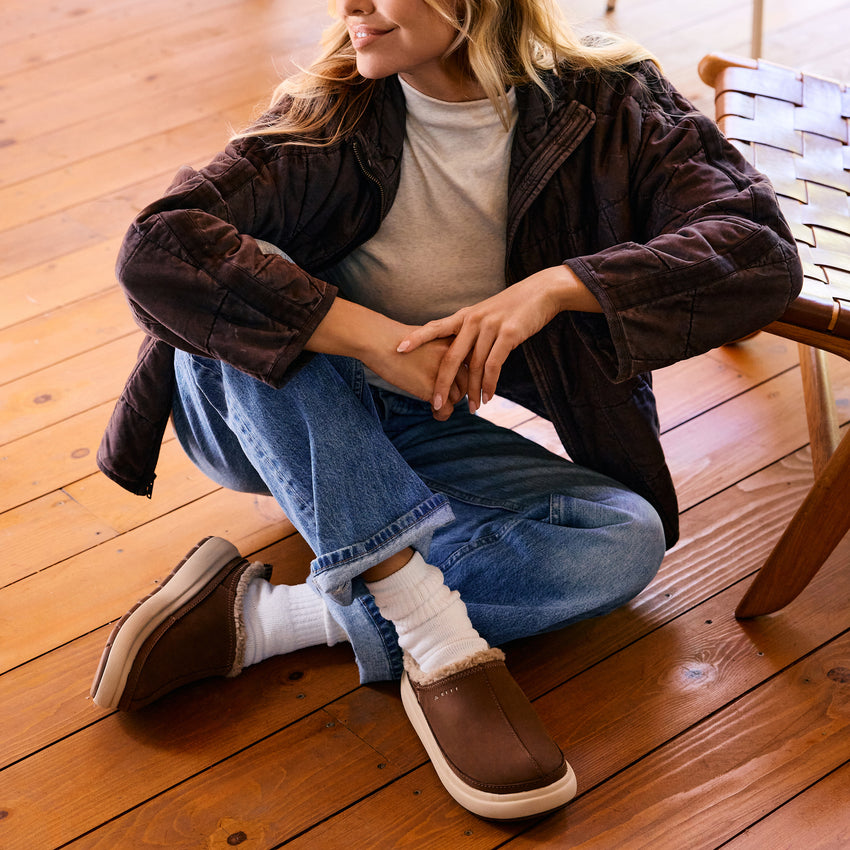Weekend Low Brooke brown shoes angled toward the camera on a seated woman, showcasing comfortable easy on and off style