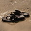 Pair of Fanning H2O men's sandals facing left on beach sand with water-friendly, cushioned footbeds and arch support.