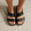 Feet wearing black Cali Solana sandals facing forward on neutral fabric, highlighting cushioned, water-friendly platform sandals.