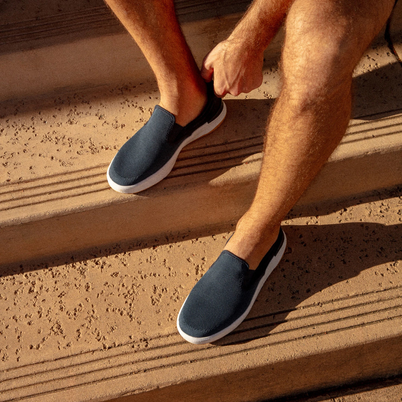 Del Mar Slip On facing left on feet, men's blue slip-on sneaker with breathable knit upper and cushioned sole for all-day comfort