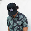 Man wearing a black Townsend Hat facing downward, highlighting comfort and surf-inspired beach apparel style.